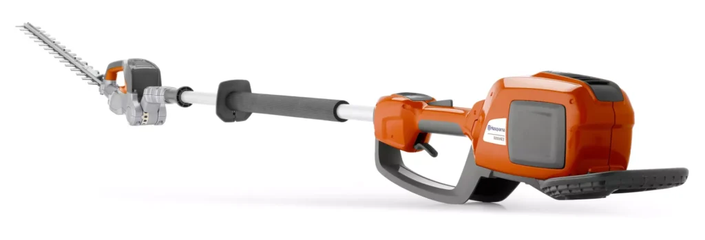 Eine orange-schwarze Heckenschere mit langem Griff auf weißem Hintergrund.